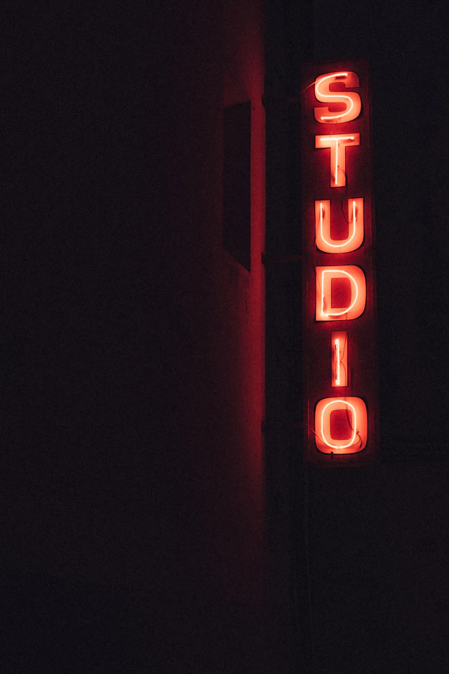 Red neon sign reading STUDIO on a dark wall