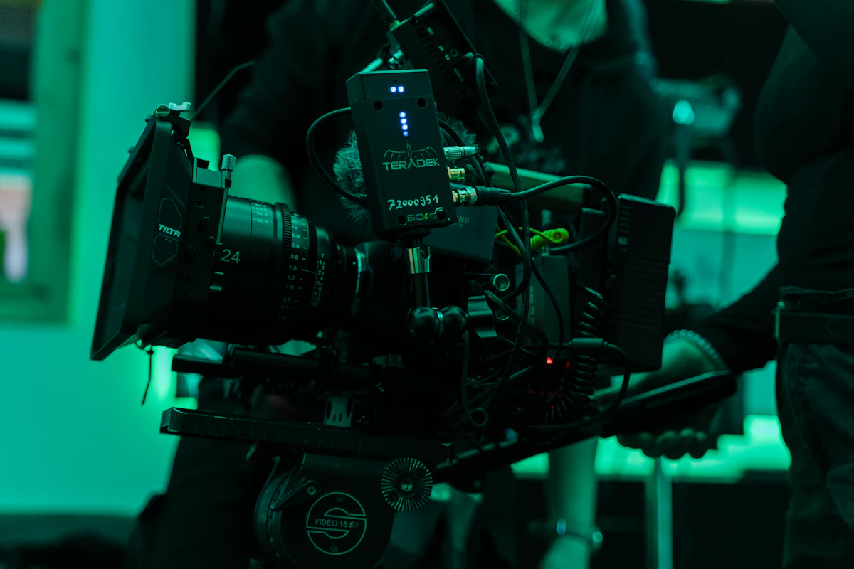 A cinema camera rig lit in green