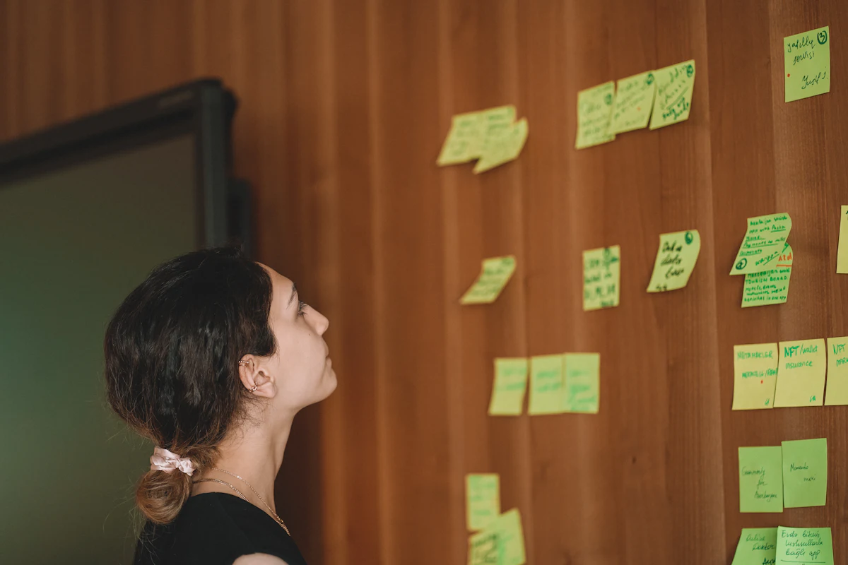 A woman planning ideas on a wall of sticky notes
